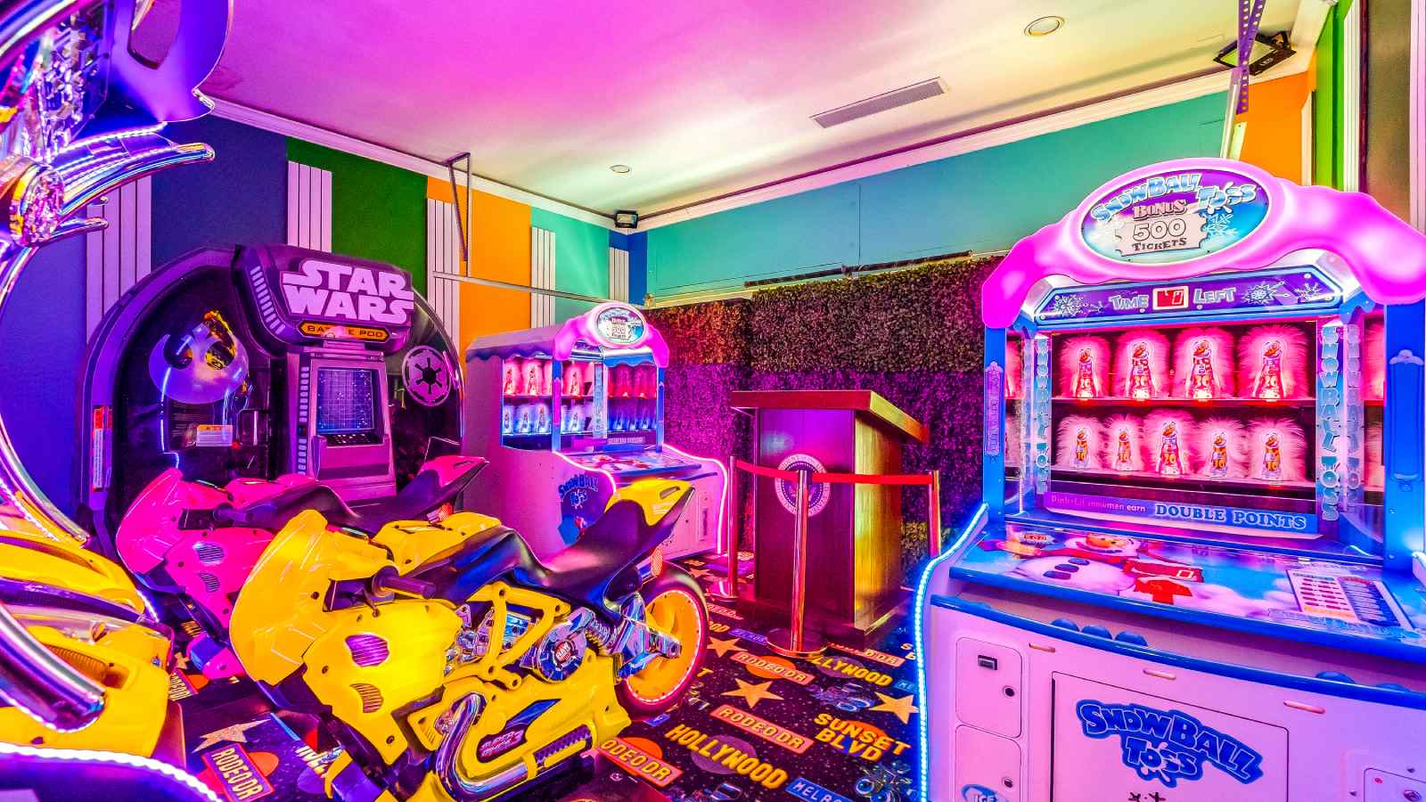 La sala de juegos incorpora múltiples máquinas recreativas para jugar a videojuegos, que combinan con una iluminación multicolor para darle a la habitación una estética retro. - imagen 9